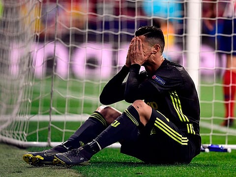 Cristiano Ronaldo covers his face.