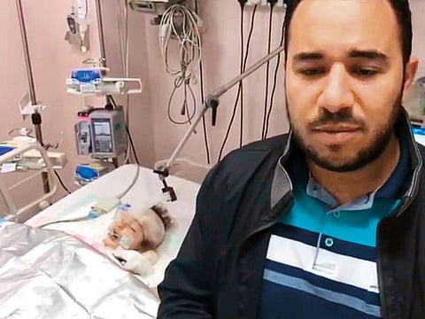 Mahmoud Nazeih with his daughter in hospital. The father says she is still in the ICU in critical condition.