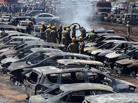 Firefighters extinguish smouldering cars after a fire broke out in a parking lot during the Aero India show at the Yelahanka Air Force Station in Bengaluru, India, February 23, 2019.