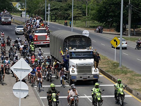 Venezuelans ride atop and alongside semi-trailers accompanying U.S. humanitarian aid destined for Venezuela, in Cucuta, Colombia, Saturday, Feb. 23, 2019