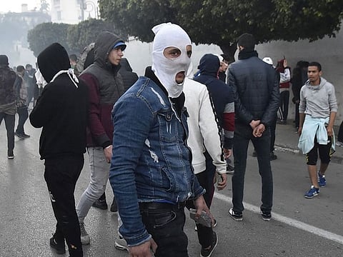 A picture taken on February 22, 2019 shows Algerian protesters as police in riot gear fired tear gas and set up a security cordon to block access to the presidential palace by the demonstrators who responded with stone-throwing.