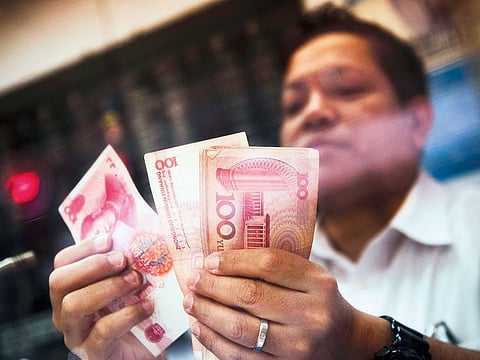 A currency exchange staff counts yuan notes in Hong Kong.