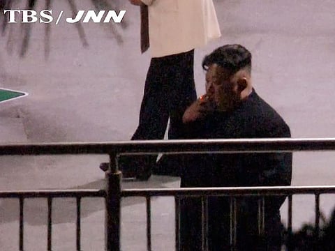 In this image made from Japan’s TBS TV video on early Tuesday, Feb. 26, 2019, North Korean leader Kim Jong Un, a habitual smoker, takes a pre-dawn smoke break at the train station in Nanning, China