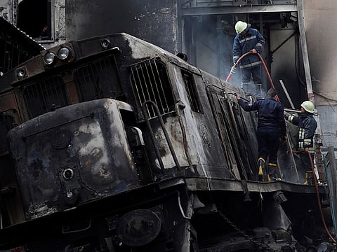 Rescue workers put out a fire after a deadly crash at the main train station in Cairo, Egypt, February 27, 2019.