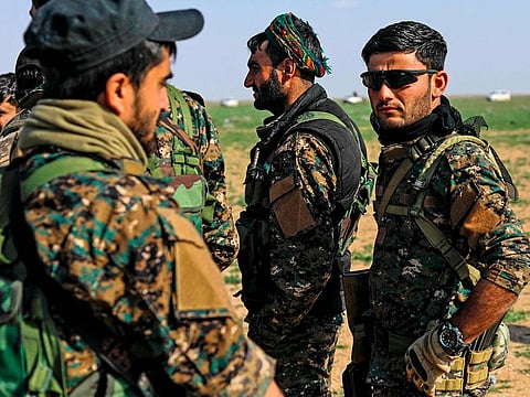 Fighters with the US-backed Syrian Democratic Forces (SDF) gather at a scanning area for people who are evacuated from Daesh embattled holdout of Baghouz