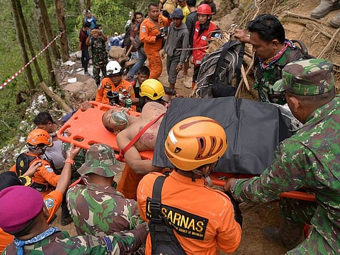 Rescuers carry a survivor of a collapsed mine on a stretcher in Bolaang Mongondow, North Sulawesi, Indonesia, Thursday, Feb. 28, 2019.
