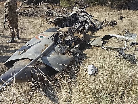 A Pakistani soldier stands guard near the wreckage of an Indian plane shot down by the Pakistan military on Wednesday, in Hurran, near the Line of Control in Pakistani Kashmir, on Thursday, February 28, 2019.