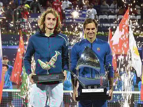 Roger Federer and Stefanos Tsitsipas pose with their trophies.