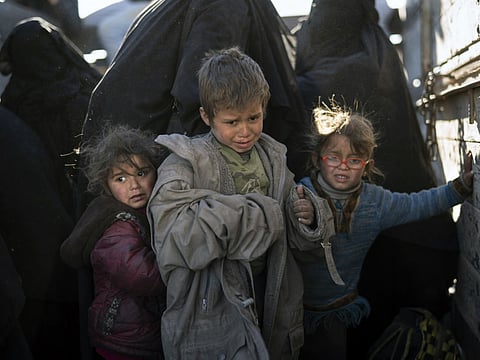 Women and children arrive at an SDF screening area in the desert outside Baghouz, Syria.