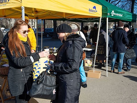 Members of the Reform party (L) and Central party campaign on March 2, 2019 in Tallinn, on the eve of Estonia's general elections.