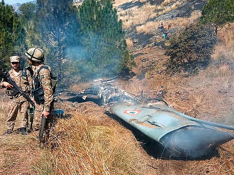 Pakistani soldiers stand next to what Pakistan says is the wreckage of an Indian fighter jet shot down in Pakistan controled Kashmir at Somani area in Bhimbar district near the Line of Control on February 27, 2019.