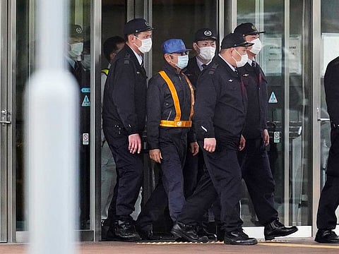 Carlos Ghosn dressed as a workman, center in blue hat, walks out of the Tokyo Detention House in Tokyo, Japan, on Wednesday, March 6, 2019.
