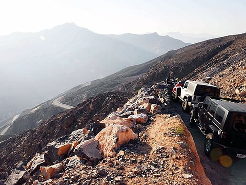 A group of visitors manages to find a vantage point to chill and soak up the magnificent view of the Hajar Mountains.
