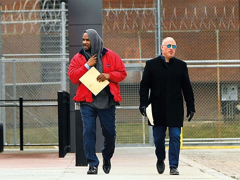 Singer R. Kelly(left), walks with his attorney Steve Greenberg