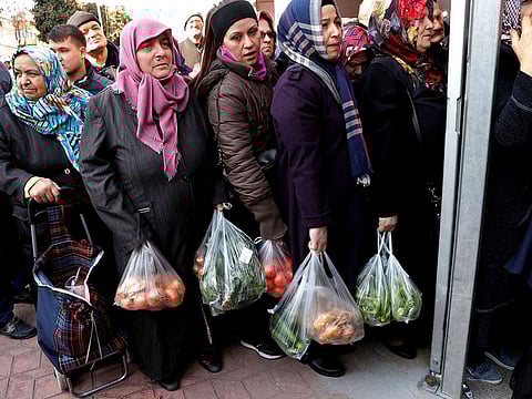 People wait in line to buy vegetables sold in a tent set up by the municipality in the Bayrampasa district of Istanbul, Turkey