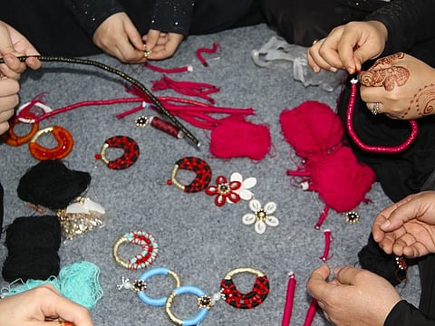 Refugee women working together to handcraft jewellery under a joint initiative by designer Huma Adnan and UNHCR.
