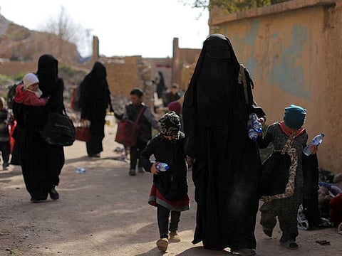 Families of Daesh fighters walk as they surrendered in the village of Baghouz, Deir Al Zor province, Syria March 12, 2019.