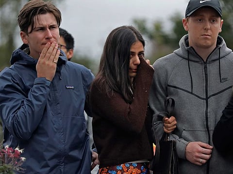 Mourners paying their respects at a makeshift memorial near the Masjid Al Noor mosque, Saturday, March 16, 2019, in Christchurch, New Zealand. The white supremacist gunman appeared in court Saturday charged with murder in the mosque assaults that killed dozens of people and led to the prime minister to call for a tightening of national gun laws.