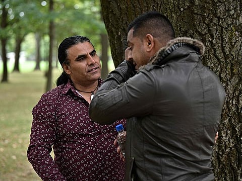 Afghan refugee and local resident Abdul Aziz (L), 48, speaks with a man who came to thank him for his bravery, during an interview with AFP in Christchurch on March 17, 2019, two days after he chased a gunman during a shooting incident at the Linwood Mosque in the city.