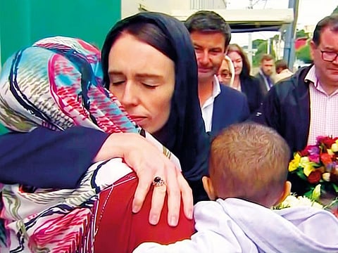 New Zealand’s Prime Minister Jacinda Ardern, center, hugs and consoles a woman as she visited Kilbirnie Mosque to lay flowers among tributes to Christchurch attack victims, in Wellington.