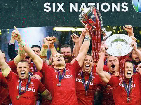 Wales' lock Alun Wyn Jones (C) holds up the trophy after being crowned Six Nations rugby champions after beating Ireland at the Principality Stadium in Cardiff, south Wales.