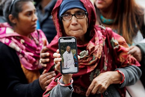 A woman holds up a photo of her husband who she says is missing after the mosque attacks, outside a community centre near Al Noor mosque in Christchurch, New Zealand, on March 16, 2019.