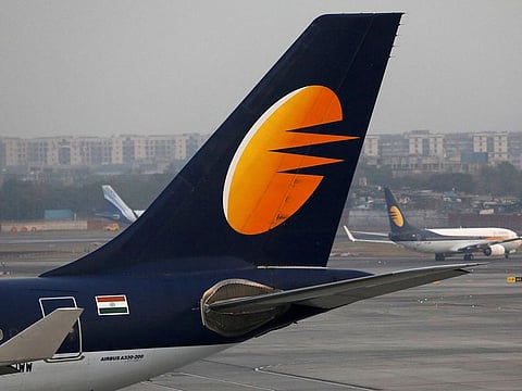 A Jet Airways plane is parked as another moves to runway at the Chhatrapati Shivaji International airport in Mumbai, India