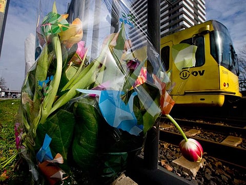 A tram passes flowers placed at the site of a shooting incident on a tram, in Utrecht, Netherlands, Tuesday, March 19, 2019.
