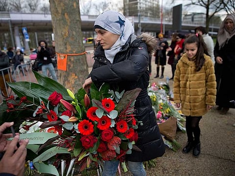 Women representing Utrecht's Muslim community lay a wreath at a makeshift memorial for the victims of a shooting incident in a tram in Utrecht, Netherlands.