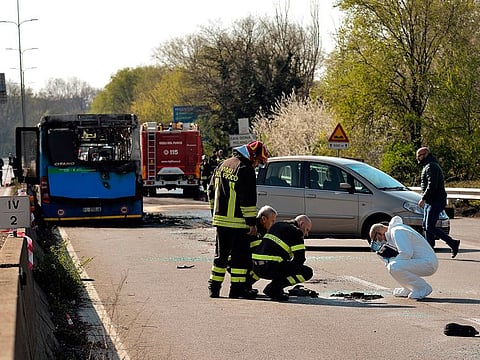 Italian forensic policemen and firefighters work by the wreckage of a school bus that was transporting some 50 children on March 20, 2019 after it was torched by the bus' driver, in San Donato Milanese, southeast of Milan