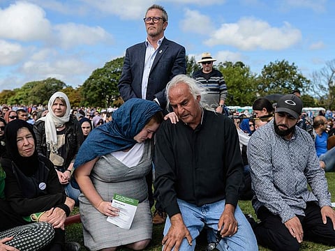 Alaska Wood, 26, (centre L) comforts Mohammed Nadir, 58, (centre R) as he cries while taking part in a two minute silence for twin mosque massacre victims in a park near the Al Noor mosque in Christchurch