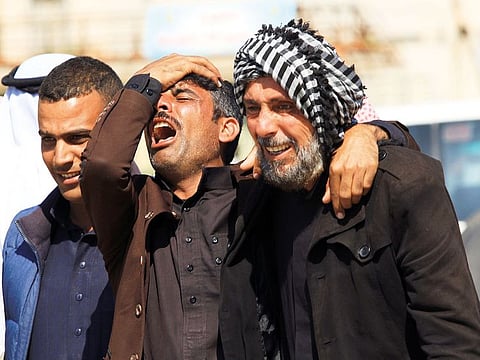 Relatives of victims of a ferry that sank in the Tigris river, cry outside the morgue in Mosul, Iraq