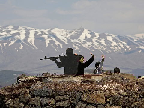 Tourists stand next to a silhouette sculpture of an Israeli soldier at an army post on Mount Bental in the Israeli-annexed Golan Heights on March 22, 2019.