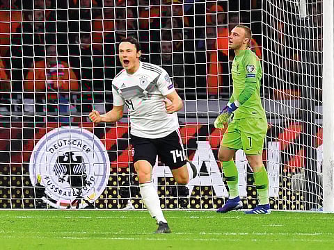Germany's defender Nico Schulz (L) celebrates after scoring their third goal during the UEFA Euro 2020 Group C qualification football match between The Netherlands and Germany at the Johan Cruyff Arena in Amsterdam on March 24, 2019.