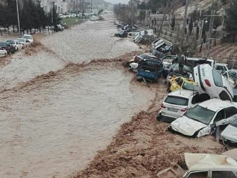 Vehicles are stacked one against another after a flash flooding In Shiraz,