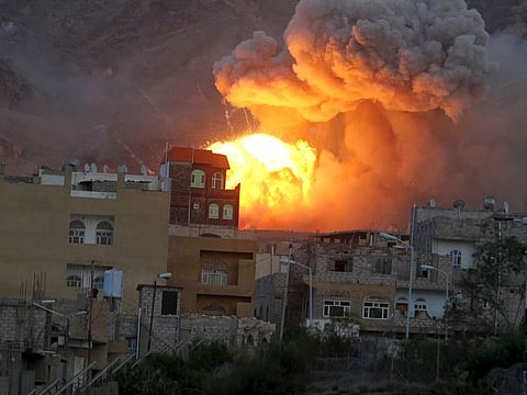 Fire and smoke billows from an army weapons depot after it was hit by an air strike in Yemen's capital Sanaa
