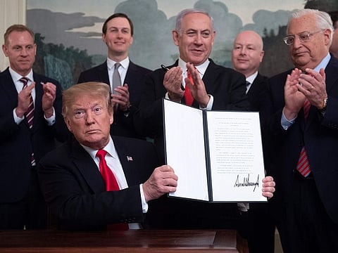 US President Donald Trump holds up a signed Proclamation on the Golan Heights alongside Israeli Prime Minister Benjamin Netanyahu in the Diplomatic Reception Room at the White House in Washington, DC.