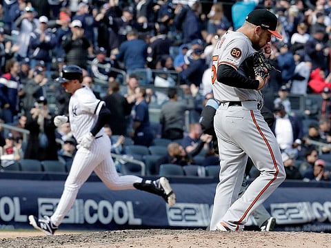Baltimore Orioles relief pitcher Paul Fry, right, walks near the mound after giving up a solo home run to first baseman Greg Bird, left, during the eighth inning of an opening day baseball game at Yankee Stadium, Thursday, March 28, 2019, in New York.