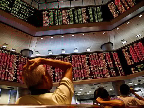 People watch trading boards at a private stock market gallery in Kuala Lumpur, Malaysia. Picture used for illustrative purposes.