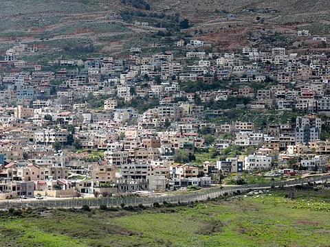 A fence separates the towns of Ain al Tineh in Syria and Majd al Shams in the Israeli-annexed Golan Heights on March 26, 2019.