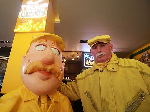 Abu Zakkour, Aleppo's so-called 'yellow man' poses near his statue erected by a local restaurant owner in the northern Syrian city