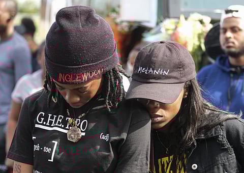 Fans of rapper Nipsey Hussle appear at a makeshift memorial in the parking lot of Hussle's Marathon Clothing store in Los Angeles, Monday, April 1, 2019.