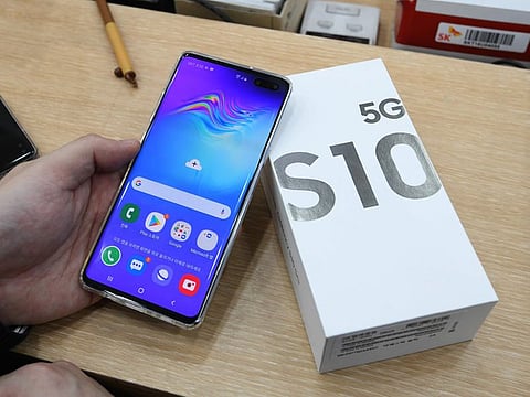A customer checks his new Samsung Galaxy S10 5G smartphone during a launch event at an SK Telecom shop in Seoul on April 5, 2019.