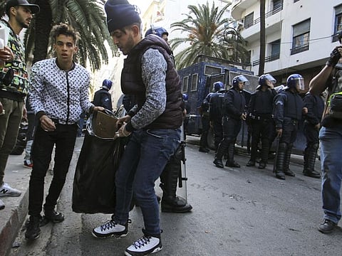 In this Friday March 29, 2019 image, groups of young people roam the streets picking up bottles and other detritus after Algeria's weekly pro-democracy protests, in a powerful demonstration of the movement's peaceful, hopeful spirit.