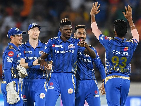Mumbai Indians cricketer Alzarri Joseph (C) celebrates with his teammates after taking six wickets during the IPL match against Sunrisers Hyderabad held at The Rajiv Gandhi International Cricket Stadium in Hyderabad on April 6, 2019.