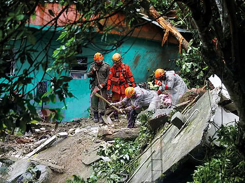Firefighters work at the site of a mudslide after a heavy rain at the Babilonia slum in Rio de Janeiro, on Tuesday.