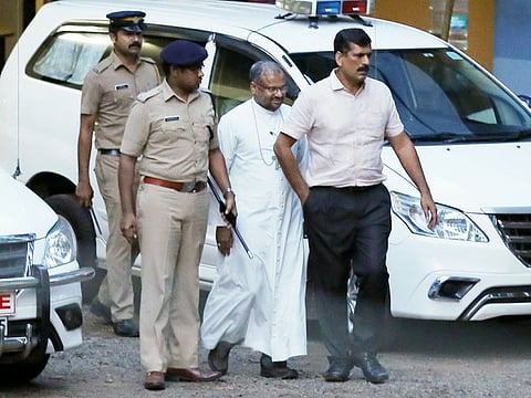 In this September 19, 2018 file photo, bishop of the Indian city of Jalandhar, Franco Mulakkal, centre, leaves after being questioned by police in Kochi, India.
