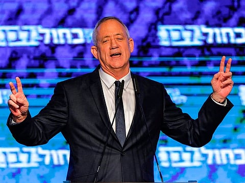 Retired Israeli general Benny Gantz, one of the leaders of the Blue and White (Kahol Lavan) political alliance, flashes the victory gesture with both hands as he appears before supporters to speak at the alliance headquarters in Tel Aviv on April 9, 2019.