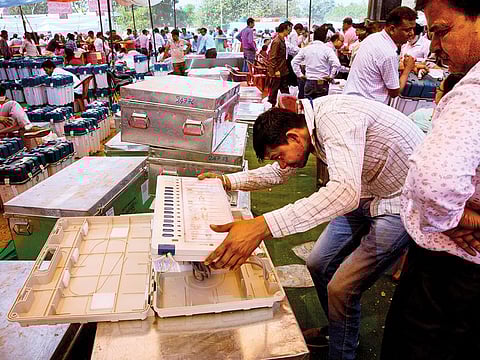 A worker checks an electronic voting machine before handing over to a polling officer for the first phase of general elections, in Ghaziabad, outskirts of New Delhi, India, Wednesday, April 10, 2019.