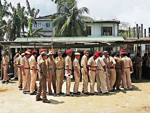 Policemen deployed on election duty stand in queue to receive their deployment slip in Majuli, Assam on Wednesday.